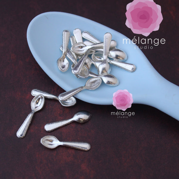 Silver miniature spoons spilling from a blue spoon