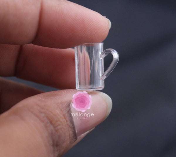 Clear resin miniature beer tankard with handle held in a hand