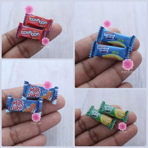 Miniature resin biscuit packets held between fingers, showing true scale